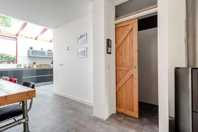a kitchen with a wooden door and a table at B&B De Ranck in Haarlem