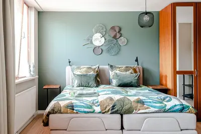 a bedroom with a bed with a blue wall at B&B De Ranck in Haarlem