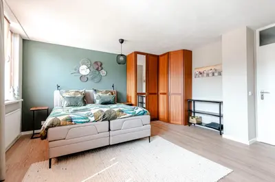 a bedroom with a bed and a blue wall at B&B De Ranck in Haarlem
