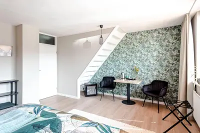 a bedroom with a bed and a table and chairs at B&B De Ranck in Haarlem