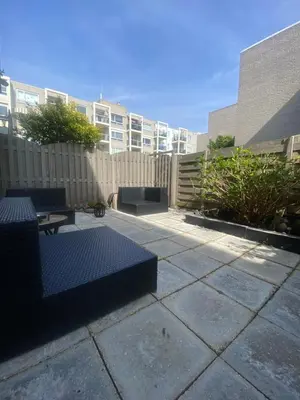 a patio with two benches and a fence at Studio Romantic in Zandvoort