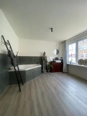 a living room with a bench and a large window at Studio Romantic in Zandvoort