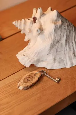 a wooden table with a key and a shell at B&B Zee-en-Zo Noordwijk in Noordwijk