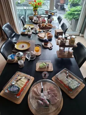 a long table with many plates of food on it at B&B Zee-en-Zo Noordwijk in Noordwijk