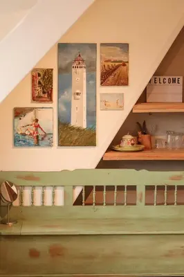 a staircase in a house with paintings on the wall at B&B Zee-en-Zo Noordwijk in Noordwijk