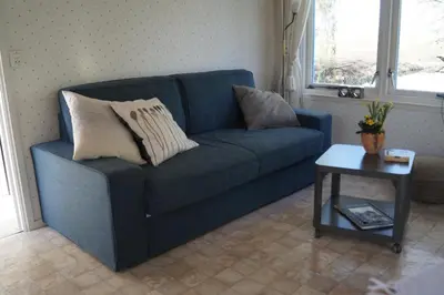 a blue couch in a living room with a table at Hortensia Eiland in Zegveld