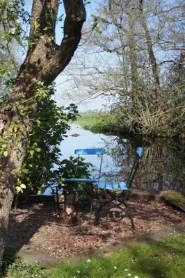 a picnic table sitting next to a river at Hortensia Eiland in Zegveld