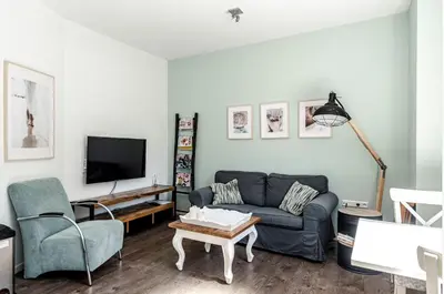 a living room with a couch and a tv at Studio en deluxe appartement Blueberry in Zandvoort