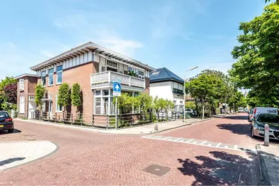 a brick building on a street with cars parked in front at Studio en deluxe appartement Blueberry in Zandvoort