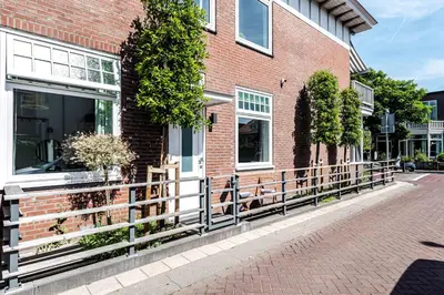 a brick building with a wooden fence in front of it at Studio en deluxe appartement Blueberry in Zandvoort
