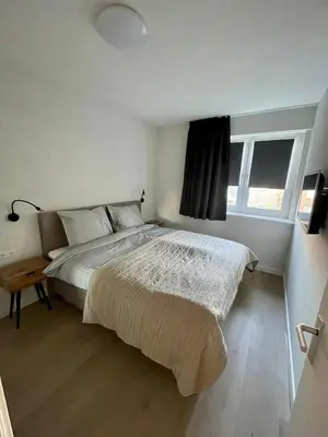 a bedroom with a large bed and a window at Appartementen Zeezicht - 7 in Katwijk aan Zee