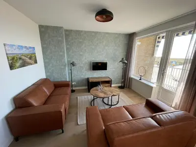a living room with a couch and a table at Appartementen Zeezicht - 7 in Katwijk aan Zee