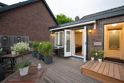 an outdoor deck with tables and potted plants at Bed & Breakfast De Vier Seizoenen in Lisse
