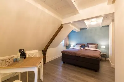 a bedroom with a bed and a table in it at Bed & Breakfast De Vier Seizoenen in Lisse