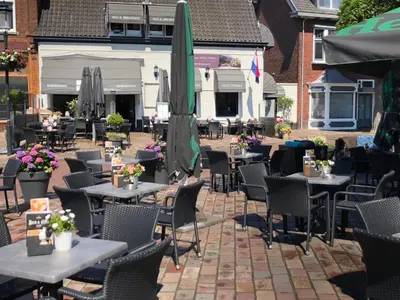 an outdoor restaurant with tables and chairs and umbrellas at Bed & Breakfast De Vier Seizoenen in Lisse