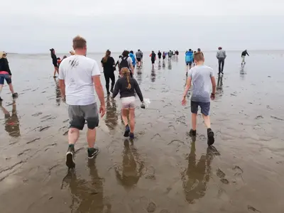 a group of people walking on the beach at B&B Suyder Cogge in Hem