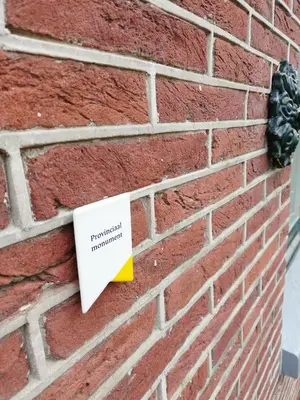 a sign on the side of a brick wall at B&B Suyder Cogge in Hem