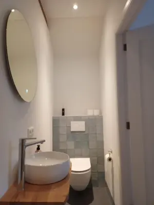 a bathroom with a tub and a toilet and a mirror at B&B Suyder Cogge in Hem