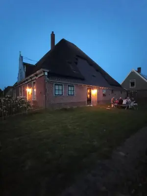 a house with a group of people sitting in the yard at B&B Suyder Cogge in Hem