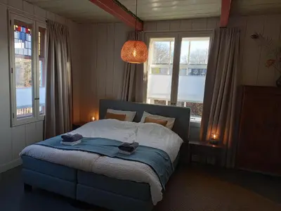 a bedroom with a blue bed with two hats on it at B&B Suyder Cogge in Hem