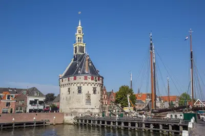 a building with a tower on the water next to a dock at B&B Suyder Cogge in Hem