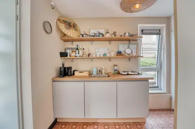 a kitchen with white cabinets and a window at Appartement YCW 'Papillon' in Rijnsaterwoude