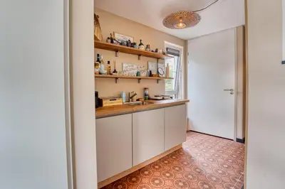a kitchen with white cabinets and a sink at Appartement YCW 'Papillon' in Rijnsaterwoude