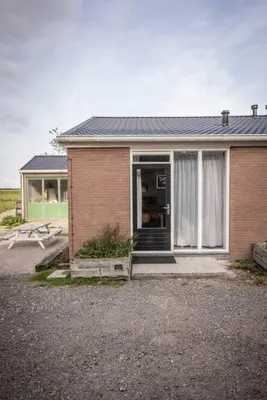 a brick house with a door and a window at De Kaasmakerij - Ruim vakantiehuisje op Huize Blokland in Hem
