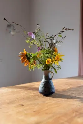 a vase filled with flowers sitting on a table at De Kaasmakerij - Ruim vakantiehuisje op Huize Blokland in Hem