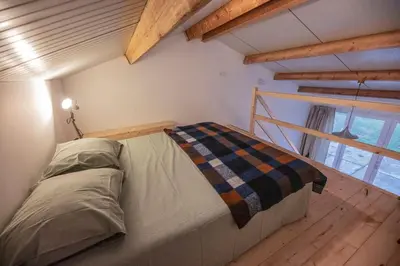 a bedroom with a bed in a room with wooden floors at 't Winkeltje - Vakantiehuisje op boerderij Huize Blokland in Hem