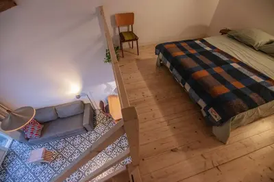 an aerial view of a bedroom with a bed and a couch at 't Winkeltje - Vakantiehuisje op boerderij Huize Blokland in Hem