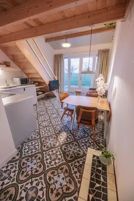 a kitchen and dining room with a table and chairs at 't Winkeltje - Vakantiehuisje op boerderij Huize Blokland in Hem