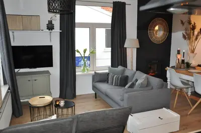 a living room with a gray couch and a table at Sunny Reef in Egmond aan Zee