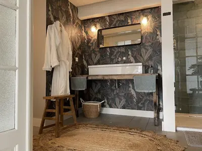 a bathroom with a sink and a mirror at Bed & Breakfast [H]eerlijk! in De Kwakel