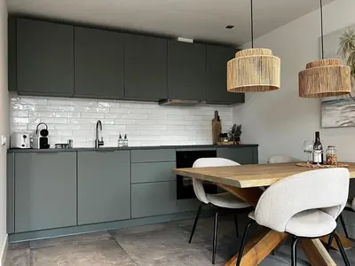 a kitchen with green cabinets and a wooden table at Olive Beach, luxury beachhouse 150 m from the beach in Noordwijk aan Zee