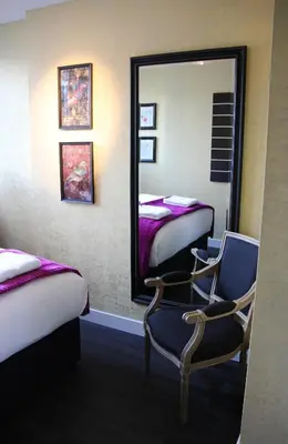 a room with two beds and a mirror and a chair at House of Freddy in Amsterdam