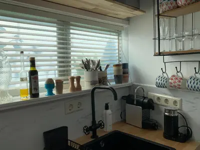 a kitchen counter with a sink and a window at Appartement 't Loft in Zandvoort