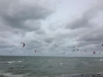 a bunch of kites flying in the sky over the ocean at Appartement 't Loft in Zandvoort