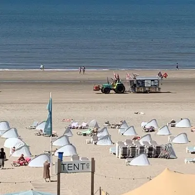 a beach with umbrellas and people on the sand at Appartement 't Loft in Zandvoort