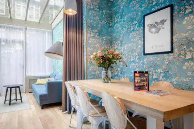 a dining room with a table and blue wallpaper at Musea Hotel & Apartments in Amsterdam