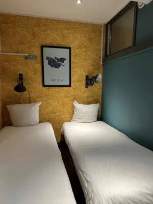 two beds sitting next to each other in a room at Musea Hotel & Apartments in Amsterdam
