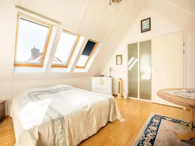 a bedroom with a bed and a bathroom with windows at Comfy holiday home in Hoorn with French balcony in Hoorn