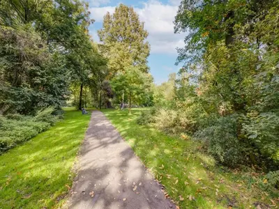 a path through a park with trees and grass at Comfy holiday home in Hoorn with French balcony in Hoorn
