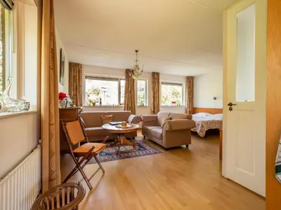 a living room with a couch and a table at Comfy holiday home in Hoorn with French balcony in Hoorn