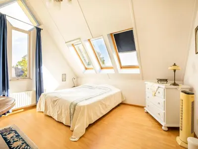 a bedroom with a bed and some windows at Comfy holiday home in Hoorn with French balcony in Hoorn