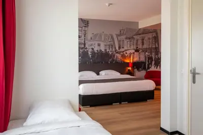 a bedroom with two beds and a wall mural at Bastion Hotel Amersfoort in Amersfoort