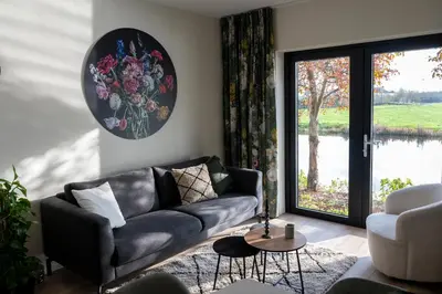 a living room with a couch and a large window at 5 persons Tulpenacker Comfort in Roelofarendsveen