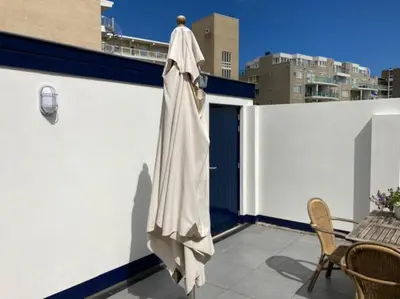 a white umbrella on the side of a building at Have a nice stay! - Beachhouse Stranddistel 100m from the beach in Noordwijk aan Zee