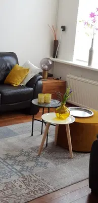a living room with two tables and a couch at Vakantiehuis Katwijk in Katwijk