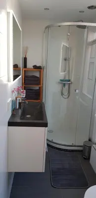 a small bathroom with a shower and a sink at Vakantiehuis Katwijk in Katwijk